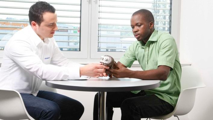 A technician explains various prosthesis components to a woman. 